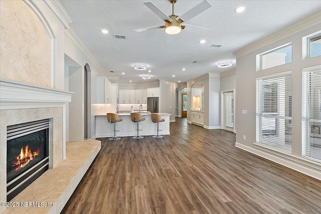 104 Haverhill Dr, Ponte Vedra Beach, FL 32082 - living area featuring ornamental molding, a premium fireplace, dark wood-style flooring, ceiling fan, and a textured ceiling