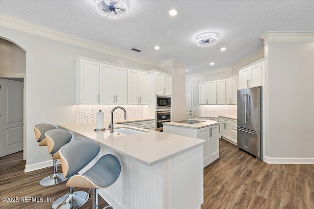 104 Haverhill Dr, Ponte Vedra Beach, FL 32082 - kitchen featuring stainless steel appliances, dark wood finished floors, a peninsula, light countertops, and a kitchen breakfast bar