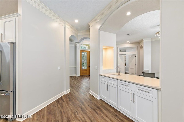 104 Haverhill Dr, Ponte Vedra Beach, FL 32082 - kitchen with arched walkways, freestanding refrigerator, crown molding, dark wood-style floors, and white cabinets