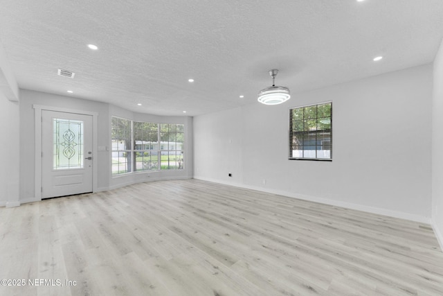 4903 Tennessee St, Jacksonville, FL 32208 - unfurnished living room with recessed lighting, plenty of natural light, light wood finished floors, a textured ceiling, and ceiling fan