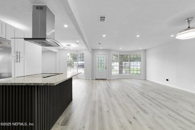 4903 Tennessee St, Jacksonville, FL 32208 - unfurnished living room featuring a textured ceiling, recessed lighting, light wood-style floors, healthy amount of natural light, and a dry bar