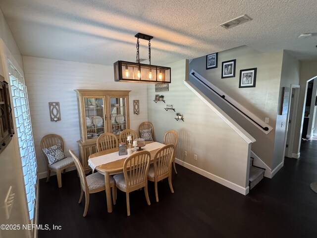 86163 Venetian Ave, Yulee, FL 32097 - dining space featuring dark wood-type flooring, stairs, and a textured ceiling