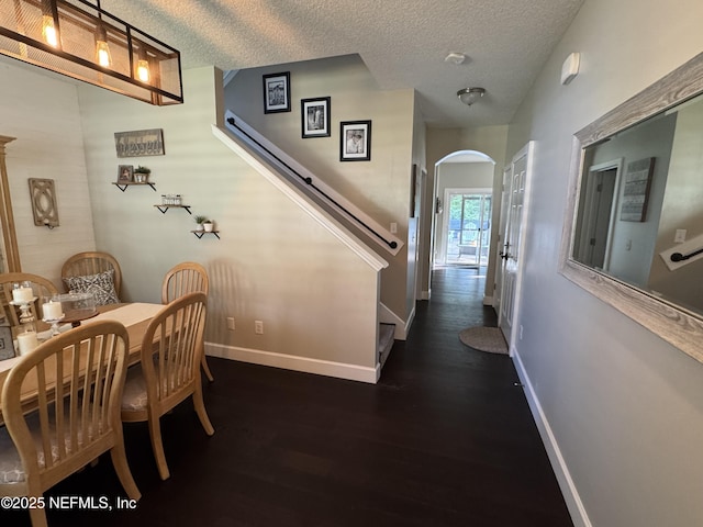 86163 Venetian Ave, Yulee, FL 32097 - hallway with arched walkways, dark wood-type flooring, and a textured ceiling