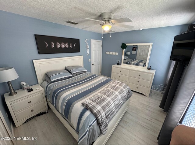 86163 Venetian Ave, Yulee, FL 32097 - bedroom with a textured ceiling, light wood-style flooring, and a ceiling fan