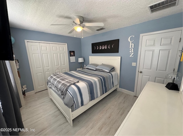 86163 Venetian Ave, Yulee, FL 32097 - bedroom featuring light wood-style flooring, a closet, a textured ceiling, and a ceiling fan