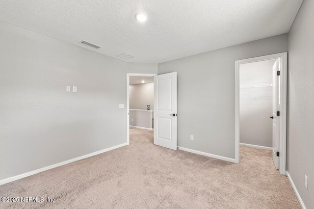 3283 Loblolly Pine Ct, Middleburg, FL 32068 - unfurnished bedroom featuring carpet, a spacious closet, a textured ceiling, and a closet