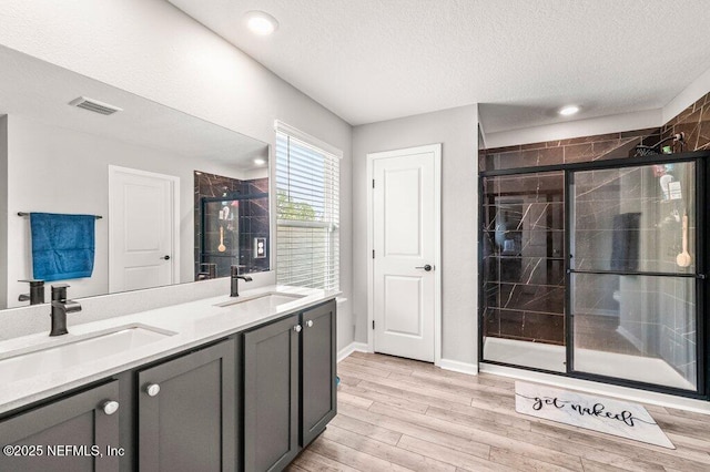 3283 Loblolly Pine Ct, Middleburg, FL 32068 - full bathroom featuring a shower stall, a textured ceiling, wood finished floors, double vanity, and recessed lighting