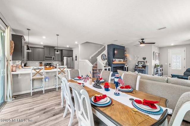 3283 Loblolly Pine Ct, Middleburg, FL 32068 - dining area with light wood finished floors, a ceiling fan, stairs, and recessed lighting