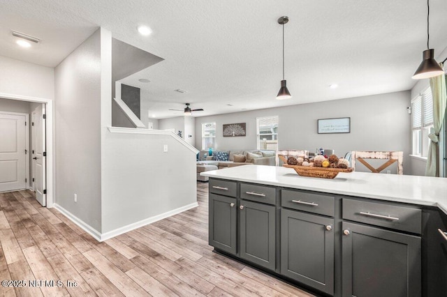 3283 Loblolly Pine Ct, Middleburg, FL 32068 - kitchen with gray cabinetry, light wood finished floors, light countertops, pendant lighting, and a textured ceiling