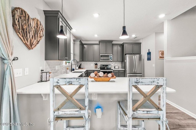 3283 Loblolly Pine Ct, Middleburg, FL 32068 - kitchen featuring stainless steel appliances, backsplash, light wood finished floors, light countertops, and a kitchen bar