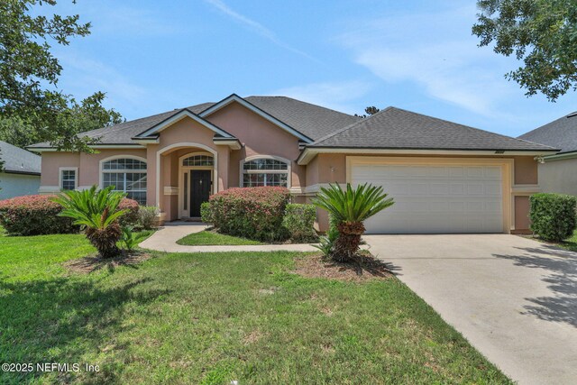 3559 Olympic Dr, Green Cove Springs, FL 32043 - ranch-style home featuring stucco siding, a garage, concrete driveway, a front lawn, and a shingled roof