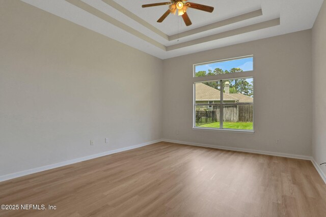 3559 Olympic Dr, Green Cove Springs, FL 32043 - empty room with light wood finished floors, ceiling fan, and a raised ceiling