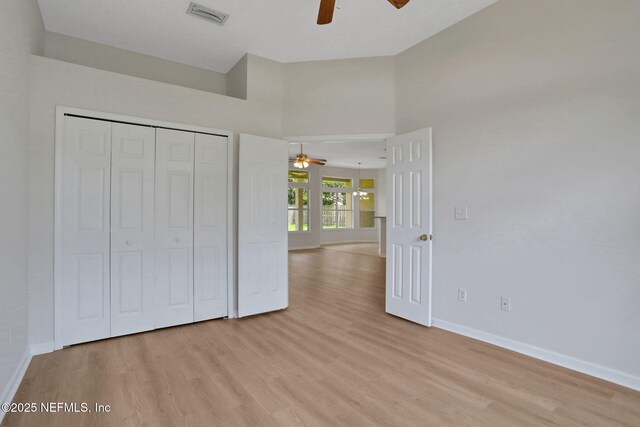 3559 Olympic Dr, Green Cove Springs, FL 32043 - unfurnished bedroom with light wood-style flooring, a closet, ceiling fan, and a towering ceiling