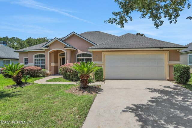 3559 Olympic Dr, Green Cove Springs, FL 32043 - view of front of property with stucco siding, concrete driveway, an attached garage, a front yard, and a shingled roof