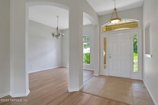 3559 Olympic Dr, Green Cove Springs, FL 32043 - entrance foyer with arched walkways, a chandelier, and wood finished floors