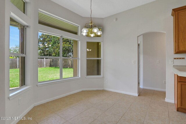 3559 Olympic Dr, Green Cove Springs, FL 32043 - unfurnished dining area featuring arched walkways, healthy amount of natural light, a chandelier, and light tile patterned floors