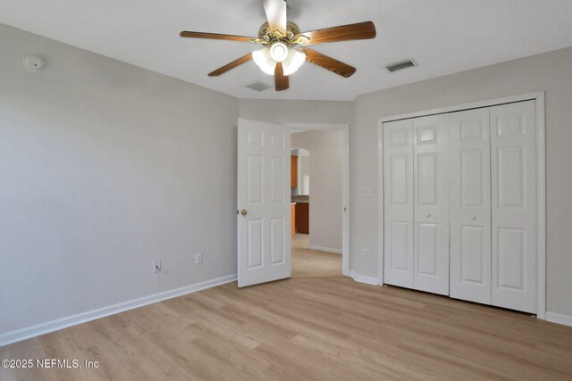 3559 Olympic Dr, Green Cove Springs, FL 32043 - unfurnished bedroom featuring light wood finished floors, arched walkways, a closet, and ceiling fan