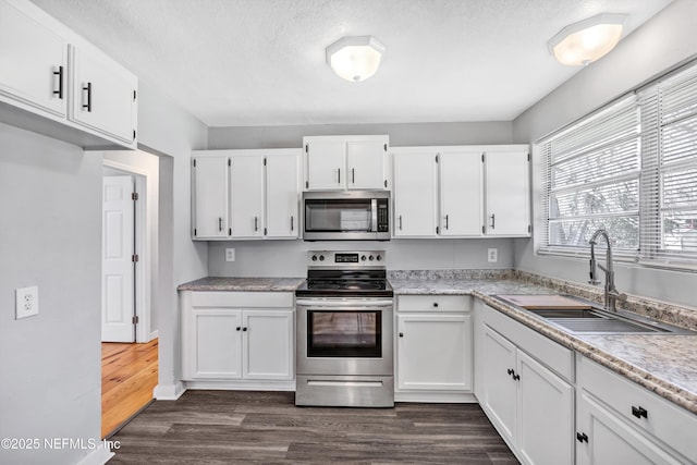 6317 Trout River Blvd, Jacksonville, FL 32219 - kitchen featuring stainless steel appliances, white cabinets, light countertops, dark wood-type flooring, and a textured ceiling