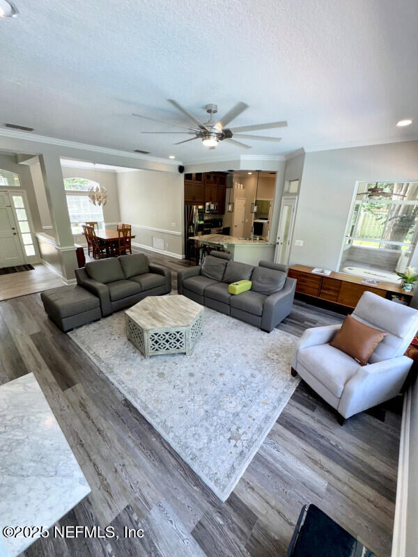 1703 Hunters Ridge Rd, Fleming Island, FL 32003 - living room featuring a textured ceiling, wood finished floors, a ceiling fan, ornamental molding, and recessed lighting