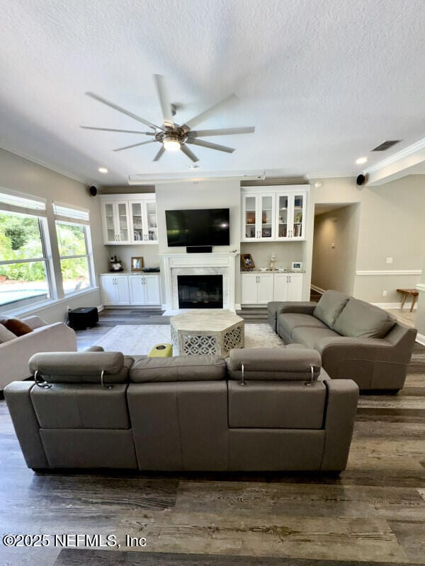 1703 Hunters Ridge Rd, Fleming Island, FL 32003 - living area with dark wood finished floors, a textured ceiling, a ceiling fan, a glass covered fireplace, and recessed lighting