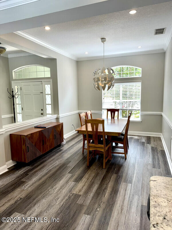 1703 Hunters Ridge Rd, Fleming Island, FL 32003 - dining space featuring ornamental molding, a chandelier, dark wood finished floors, and recessed lighting