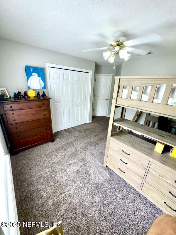 1703 Hunters Ridge Rd, Fleming Island, FL 32003 - bedroom with carpet, a closet, ceiling fan, and a textured ceiling