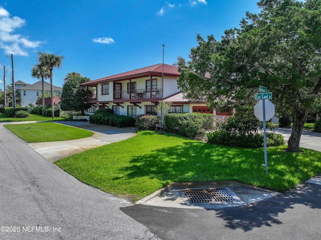 1313 E Coast Dr, Atlantic Beach, FL 32233 - view of front of house with a front yard, a tiled roof, and stucco siding
