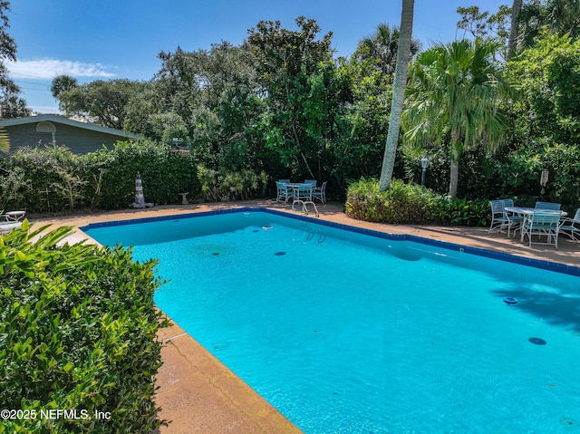 1313 E Coast Dr, Atlantic Beach, FL 32233 - swimming pool with outdoor dining space, a patio, and view of scattered trees