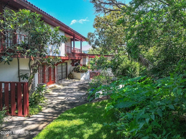 1313 E Coast Dr, Atlantic Beach, FL 32233 - view of yard with asphalt driveway, a garage, and a patio area