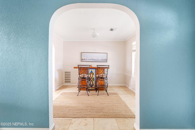 2910 Lake Shore Blvd, Jacksonville, FL 32210 - tiled dining area with arched walkways, a textured wall, and crown molding