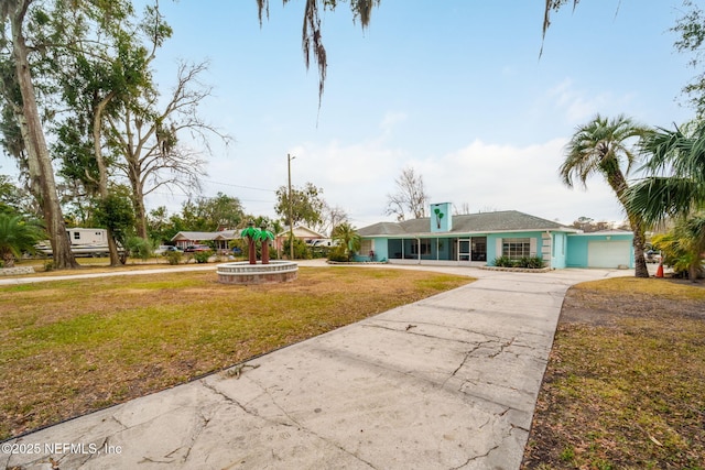 2910 Lake Shore Blvd, Jacksonville, FL 32210 - ranch-style house featuring concrete driveway, a front lawn, and a garage