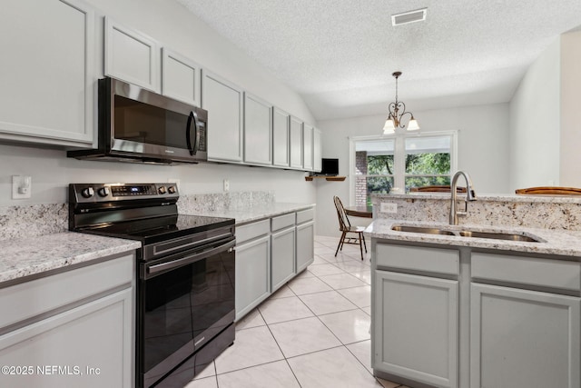 96031 Glen Laurel Ct, Yulee, FL 32097 - kitchen with black / electric stove, stainless steel microwave, a chandelier, decorative light fixtures, and light tile patterned floors