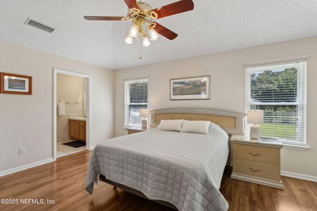 96031 Glen Laurel Ct, Yulee, FL 32097 - bedroom featuring wood finished floors, a textured ceiling, connected bathroom, and a ceiling fan