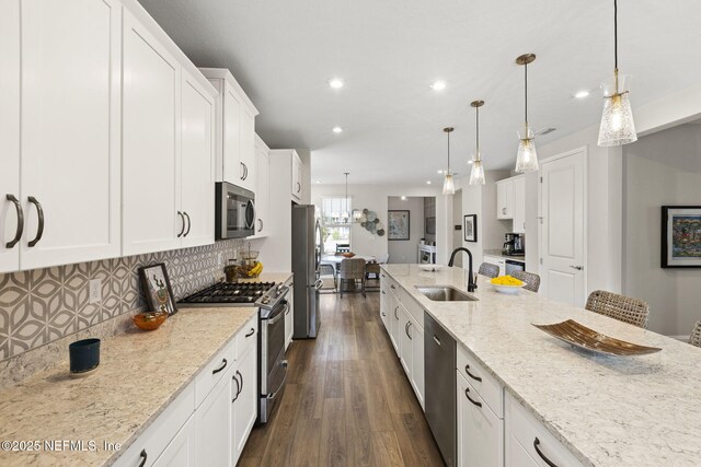 393 Ladyslipper Dr, Saint Johns, FL 32259 - kitchen featuring stainless steel appliances, dark wood finished floors, white cabinets, light stone counters, and recessed lighting
