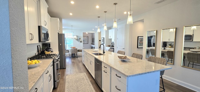 393 Ladyslipper Dr, Saint Johns, FL 32259 - kitchen featuring stainless steel appliances, dark wood-style floors, a spacious island, white cabinetry, and a breakfast bar area