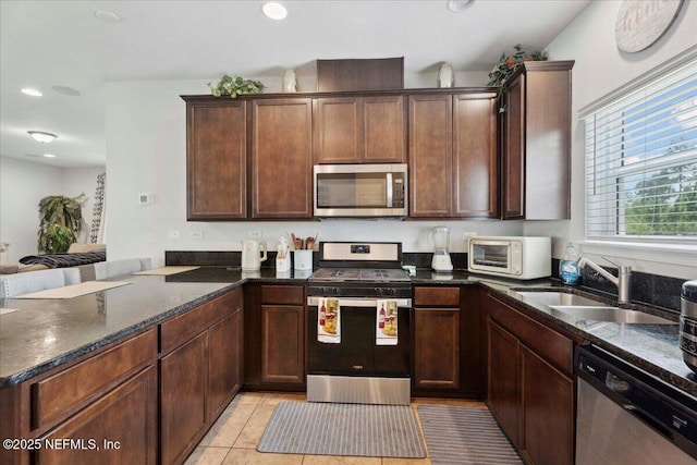 737 Windermere Way, Saint Augustine, FL 32095 - kitchen featuring appliances with stainless steel finishes, a peninsula, dark stone counters, recessed lighting, and light tile patterned floors