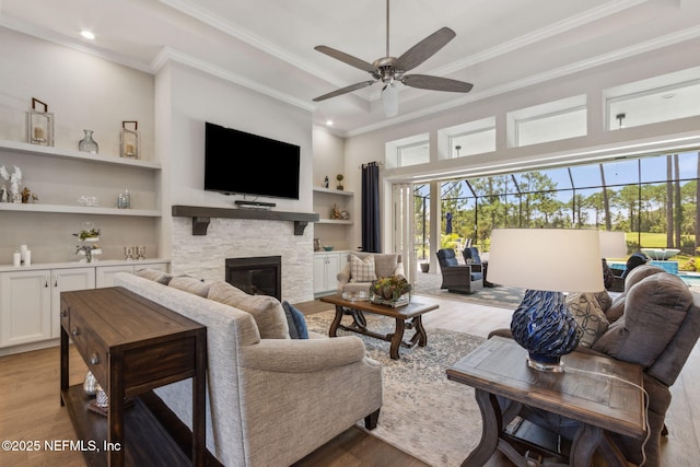 95049 Wild Cherry Dr, Fernandina Beach, FL 32034 - living area featuring light wood-type flooring, healthy amount of natural light, crown molding, a stone fireplace, and a ceiling fan