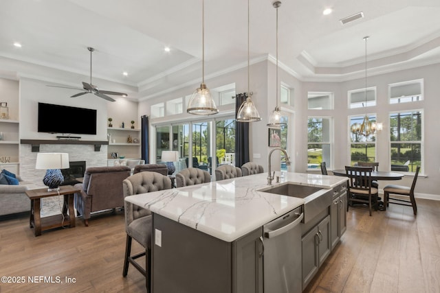 95049 Wild Cherry Dr, Fernandina Beach, FL 32034 - kitchen with a raised ceiling, dishwasher, wood-type flooring, ceiling fan, and light stone counters
