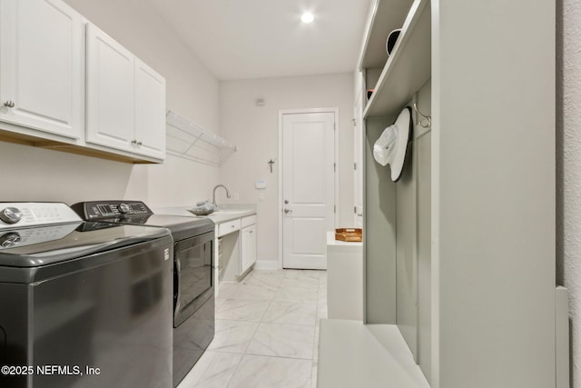 95049 Wild Cherry Dr, Fernandina Beach, FL 32034 - laundry room with washing machine and clothes dryer, cabinet space, and light marble finish floors