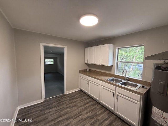 925 W 25th St, Jacksonville, FL 32209 - kitchen featuring healthy amount of natural light, white cabinets, dark wood-style floors, and electric water heater