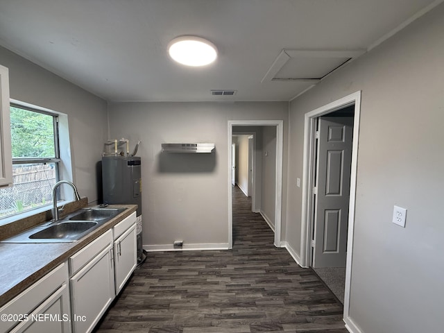 925 W 25th St, Jacksonville, FL 32209 - kitchen featuring dark wood-style floors, white cabinets, and water heater