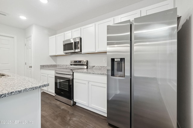 2350 Jayson Ave, Jacksonville, FL 32208 - kitchen featuring appliances with stainless steel finishes, dark wood finished floors, white cabinets, recessed lighting, and light stone counters