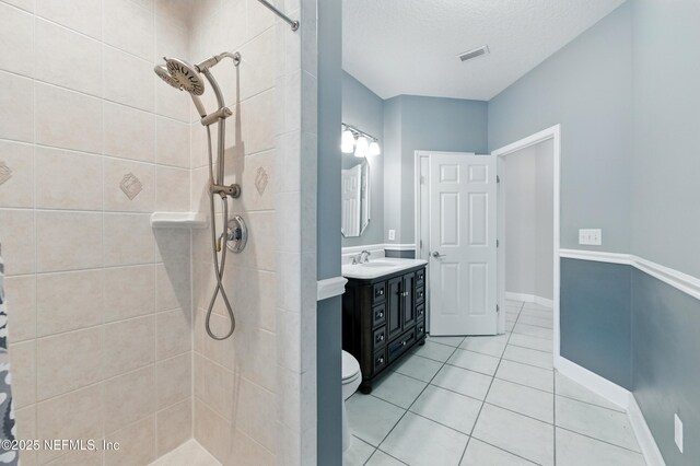 85712 Avant Rd, Yulee, FL 32097 - bathroom featuring a tile shower, vanity, tile patterned flooring, and a textured ceiling