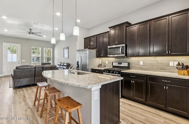240 Julep St, Yulee, FL 32097 - kitchen with appliances with stainless steel finishes, a breakfast bar area, open floor plan, light wood-style floors, and recessed lighting