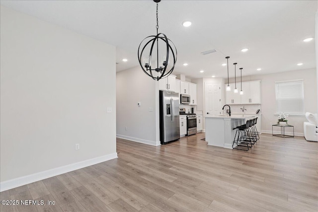 280 Cedar Elm Way, Saint Augustine, FL 32092 - kitchen featuring stainless steel appliances, a chandelier, open floor plan, a breakfast bar, and a kitchen island with sink