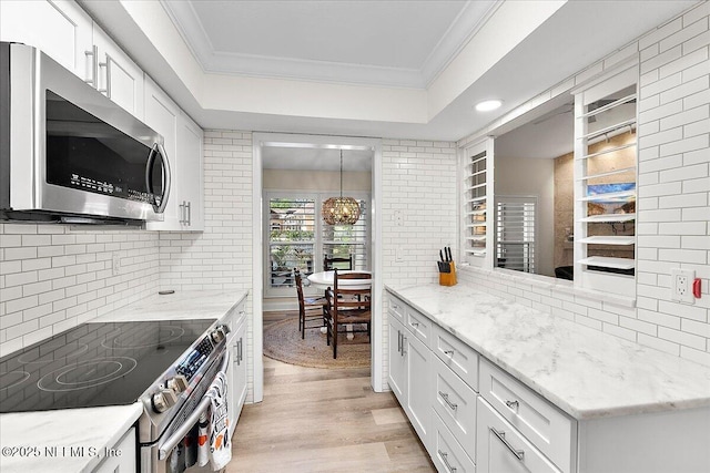 822 Coquina Bay, Ponte Vedra Beach, FL 32082 - kitchen featuring stainless steel appliances, backsplash, ornamental molding, light wood finished floors, and white cabinets