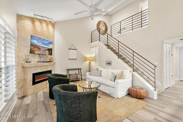 822 Coquina Bay, Ponte Vedra Beach, FL 32082 - living room featuring wood finished floors, rail lighting, stairway, ceiling fan, and a fireplace