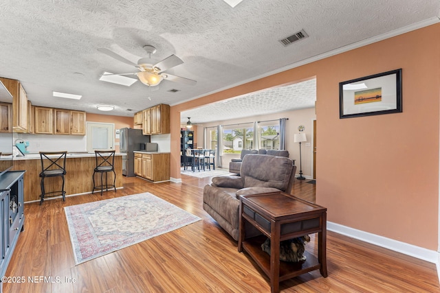 270 Drew St W, Baldwin, FL 32234 - living room with ceiling fan, light wood-type flooring, crown molding, and a textured ceiling