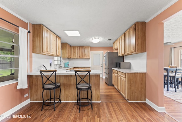 270 Drew St W, Baldwin, FL 32234 - kitchen with a textured ceiling, a peninsula, dark wood finished floors, stainless steel appliances, and light countertops