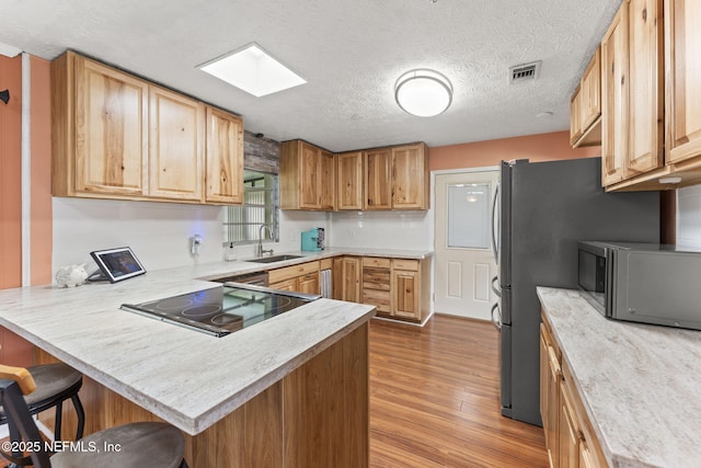 270 Drew St W, Baldwin, FL 32234 - kitchen with stainless steel microwave, a peninsula, light countertops, wood finished floors, and a kitchen bar